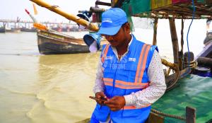 Un pêcheur en mer contribue à la conservation de la biodiversité en collectant des données avec son smartphone.